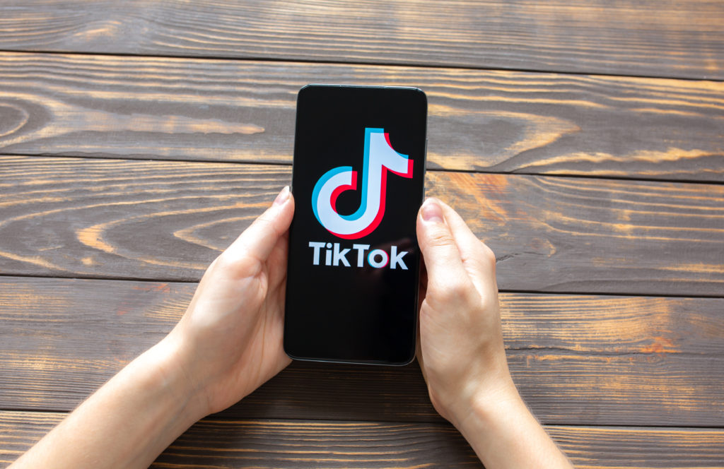 Social Media agency for tik-tok-application-modern-smartphone-social-networks-wooden-background